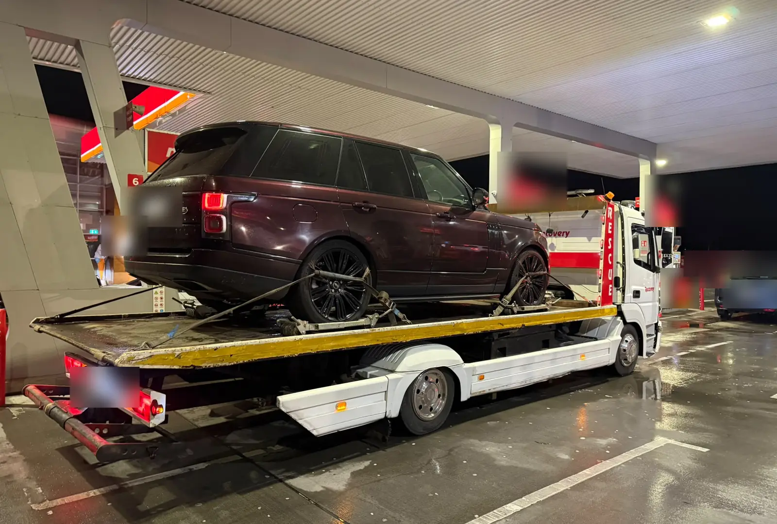 Recovery CC tow truck at night carrying a large SUV on a Dublin petrol station forecourt
