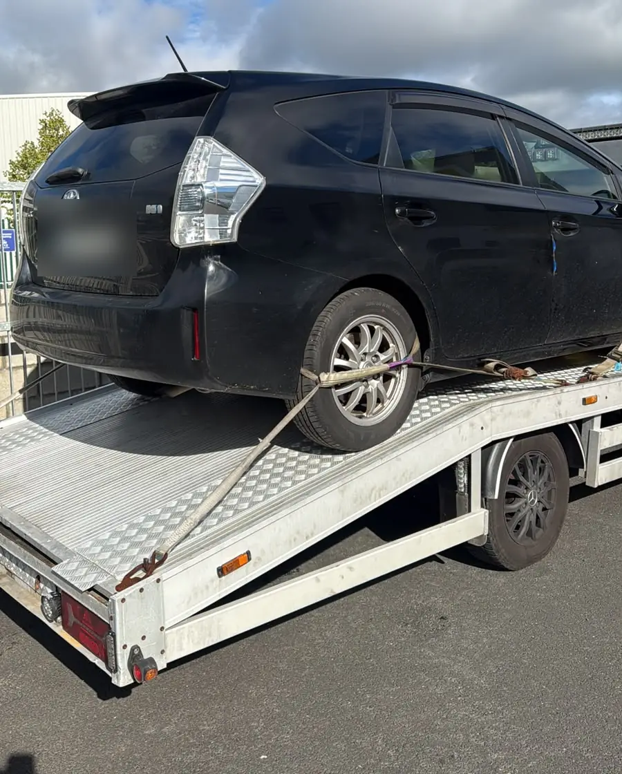 A hybrid car loaded on the tilted bed of a tow truck, hybrid and EV towing in Dublin