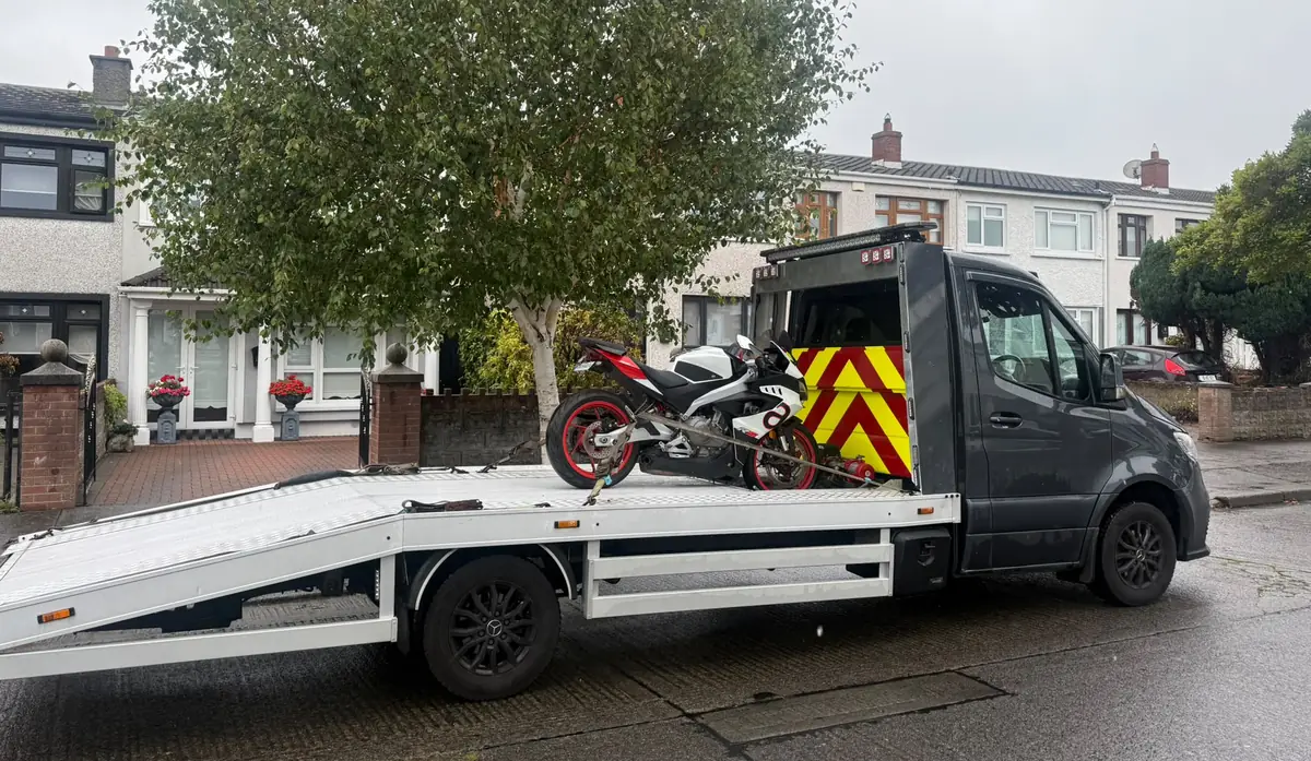 A motorcycle on a flatbed tow truck on a Dublin residential street, bike recovery