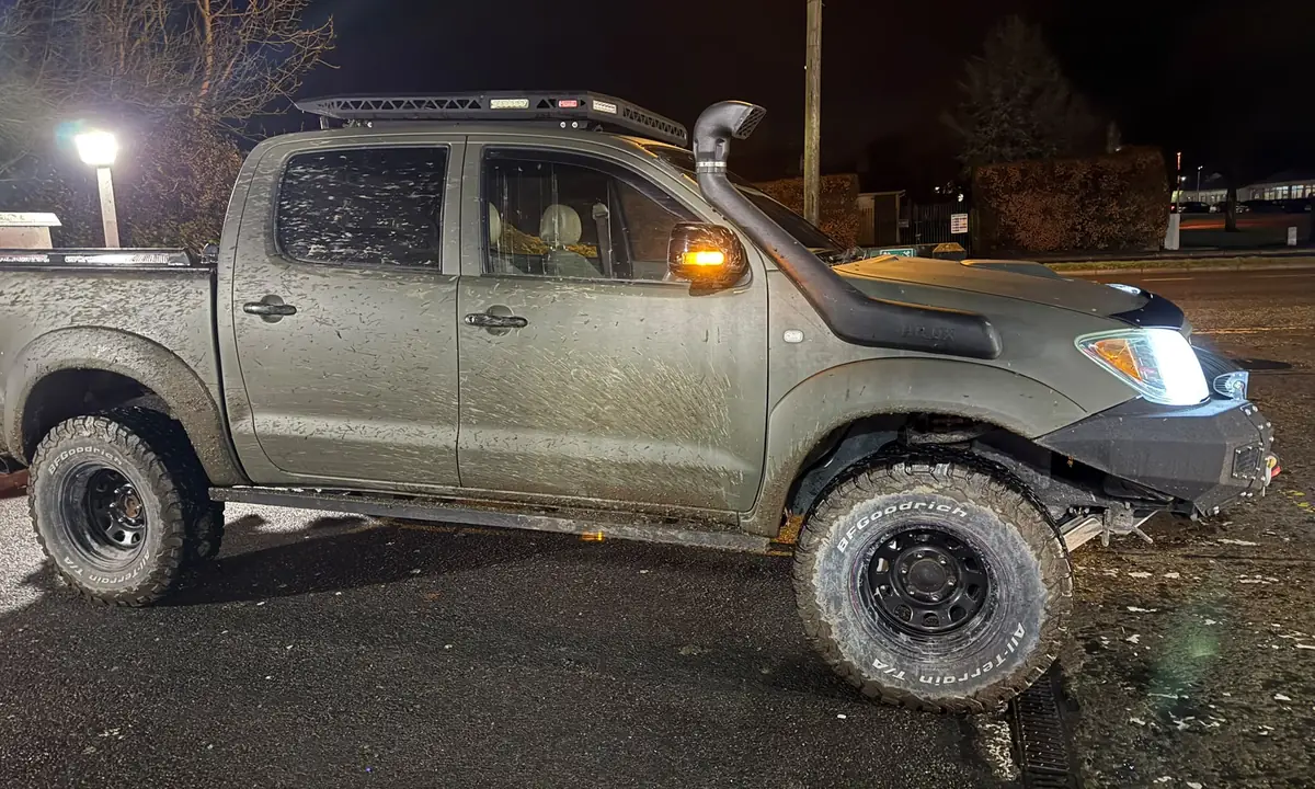 A muddy 4x4 pickup waiting for recovery at night in Dublin