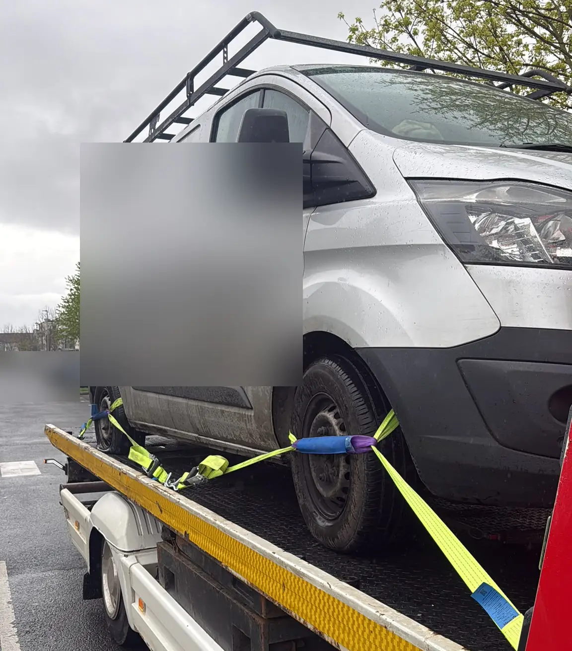 A van secured with yellow wheel straps on a recovery truck, van towing in Dublin