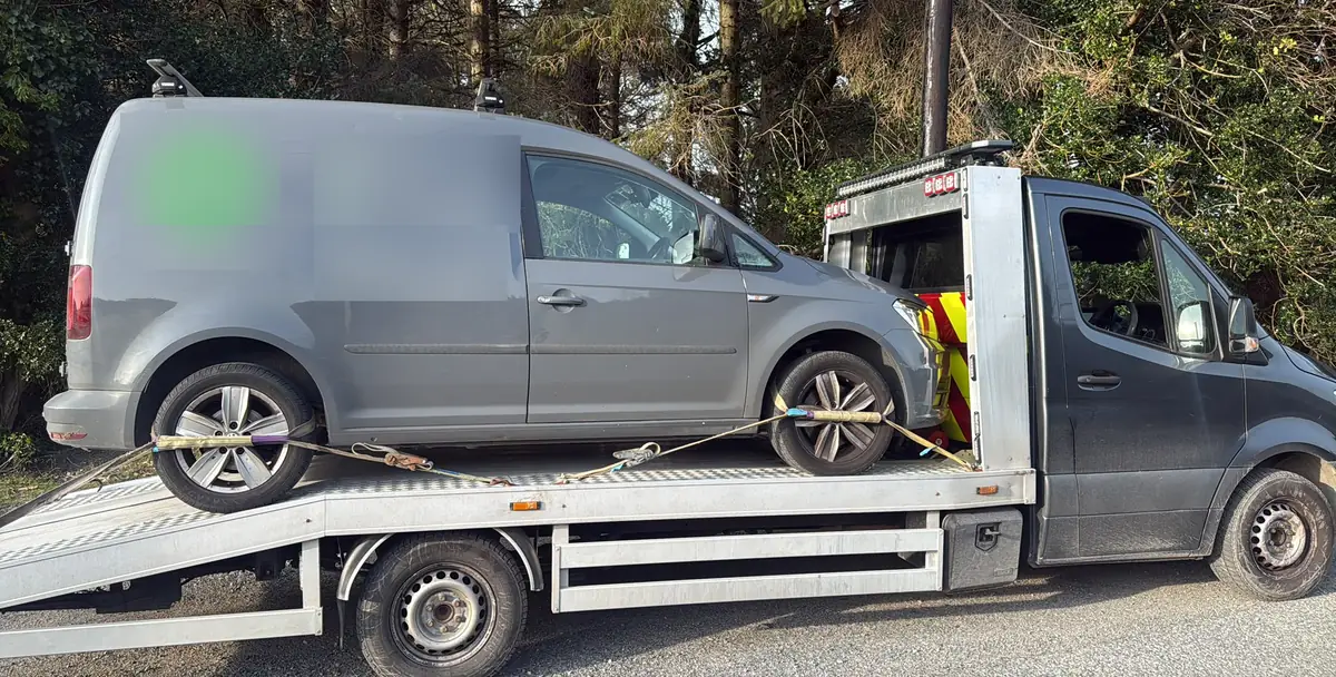 A small grey van strapped onto a flatbed for van towing in Dublin