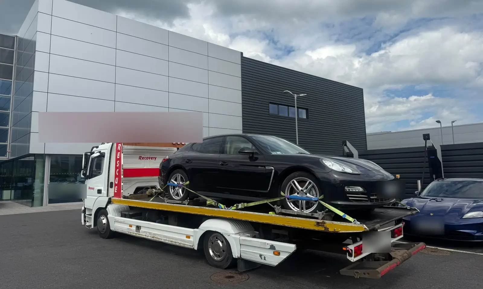 Recovery CC tow truck transporting a black sports saloon, strapped down on the flatbed in Dublin