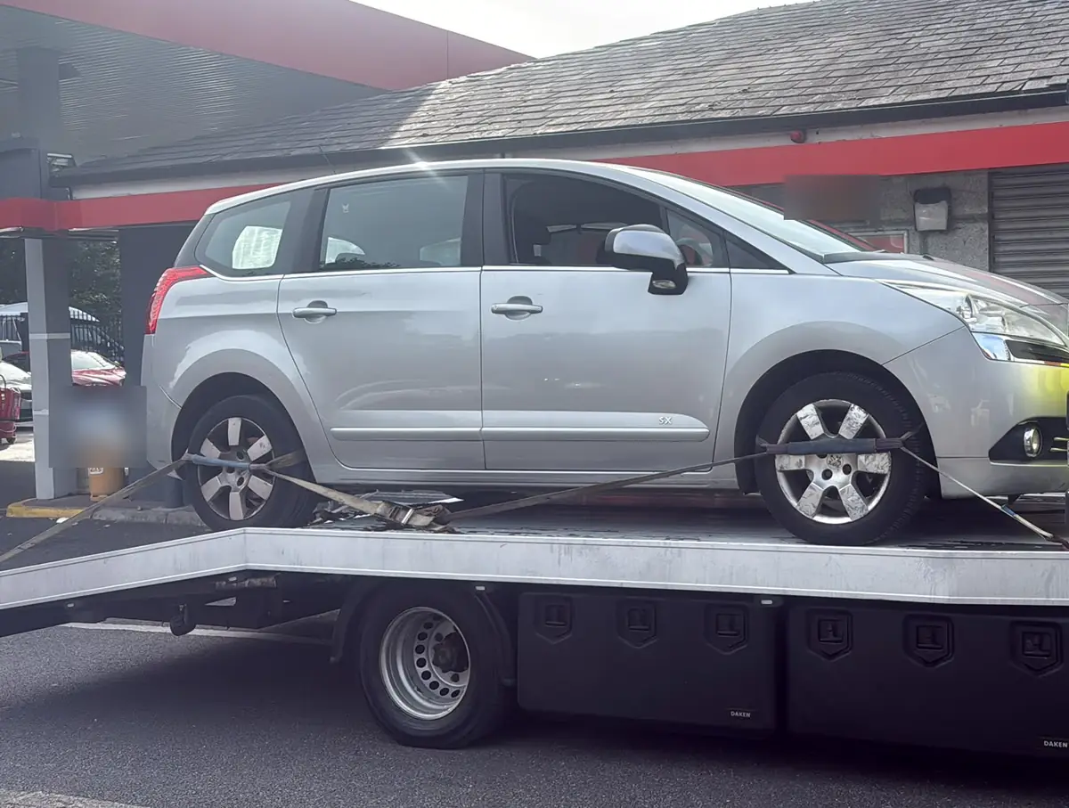 A silver people carrier strapped onto a flatbed for breakdown recovery in Dublin